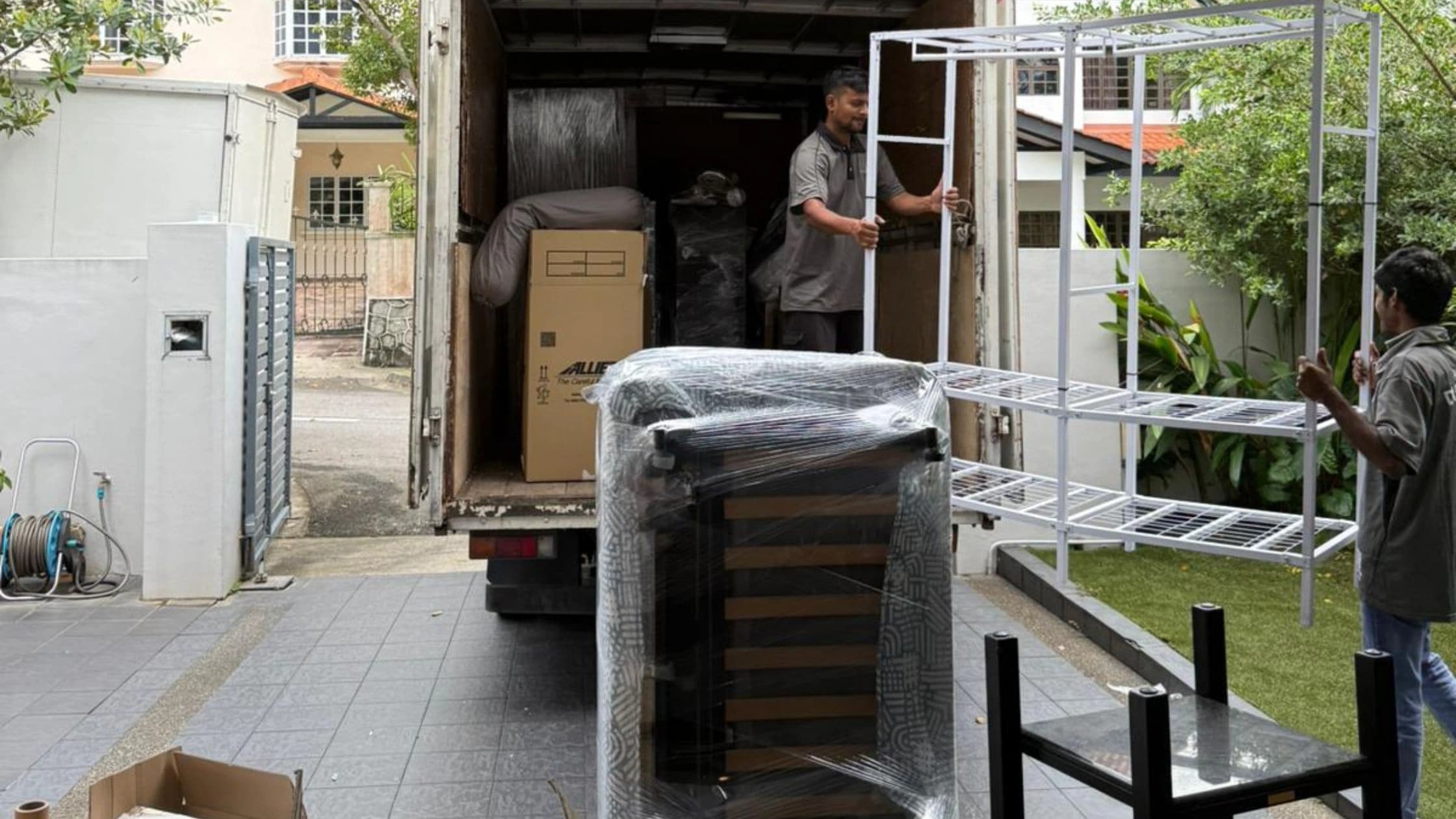 Moving Solutions crew preparing protected furniture beside a moving truck